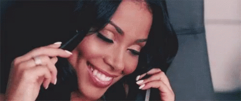 A Woman With White Nails Is Smiling While Talking On A Cell Phone GIF