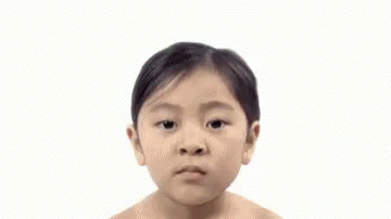 A Woman Without A Shirt Is Looking At The Camera With A Serious Look On Her Face . GIF