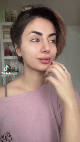A Woman Without Makeup Is Wearing A Pink Shirt And A Leopard Print Shirt . GIF