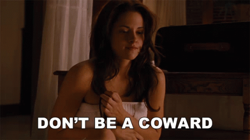 A Woman Wrapped In A Towel With The Words " Don 'T Be A Coward " Below Her GIF