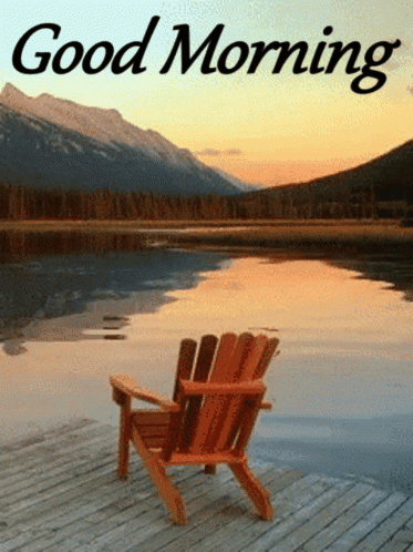 A Wooden Chair Sits On A Dock Near A Lake With Mountains In The Background And The Words Good Morning GIF