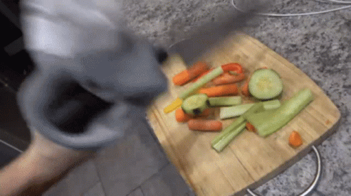 A Wooden Cutting Board With Carrots Celery And Peppers On It GIF