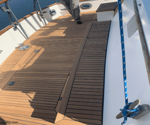 A Wooden Deck On A Boat With A Blue Rope Hanging From The Side GIF