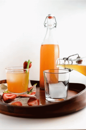 A Wooden Tray With A Bottle Of Juice And A Glass On It GIF