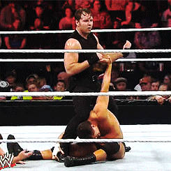 A Wrestler In A Black Tank Top Is Wrestling Another Wrestler GIF