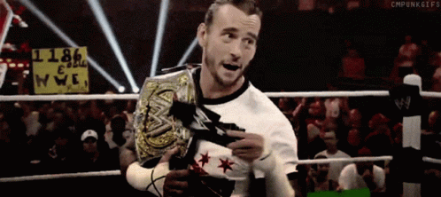 A Wrestler In A Ring With A Sign That Says 1186 On It GIF