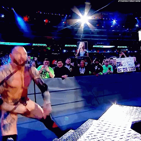 A Wrestler In A Ring With A Sign That Says Batista GIF
