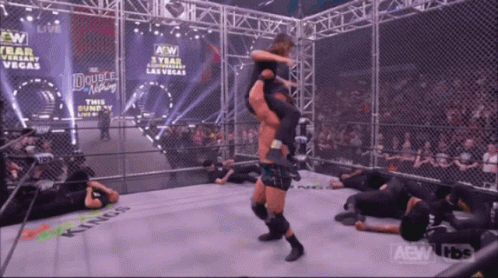 a wrestler is being lifted in the air by another wrestler in a ring that says kings