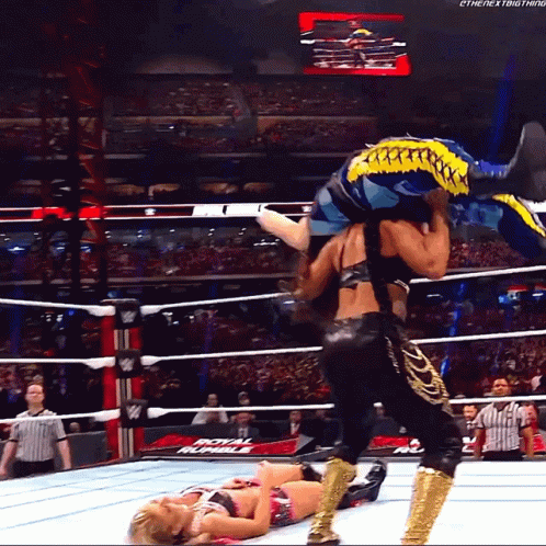 a wrestler is carrying another wrestler in a wrestling ring that says royal rumble on the bottom