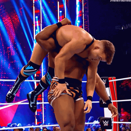 A Wrestler Is Carrying Another Wrestler On His Back GIF