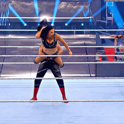 A Wrestler Is Carrying Another Wrestler On His Shoulders In A Wrestling Ring . GIF