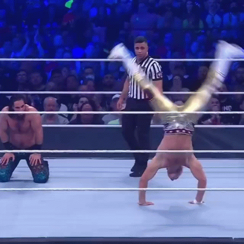 A Wrestler Is Doing A Handstand In A Wrestling Ring GIF