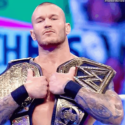 A Wrestler Is Giving A Thumbs Up While Wearing A Championship Belt GIF