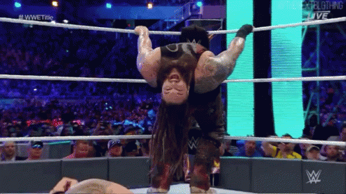 A Wrestler Is Hanging Upside Down In The Ring GIF