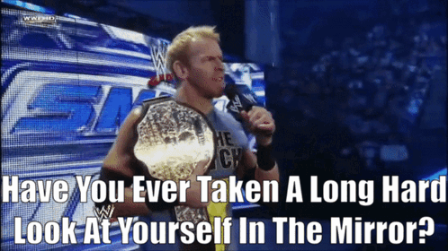 A Wrestler Is Holding A Championship Belt And Talking Into A Microphone GIF