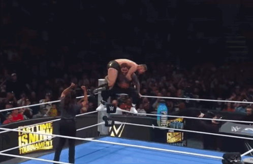 A Wrestler Is Jumping Over Another Wrestler In A Wrestling Ring With A Sign That Says Last Time Is Now Tournament GIF