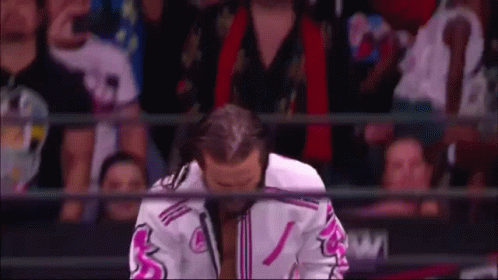 Wrestler Kneeling In Front Of Crowd In Pink And White Jacket GIF