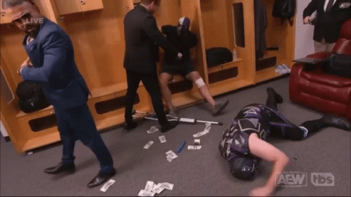 A Wrestler Is Laying On The Floor In A Locker Room With The Aew Logo On The Bottom Right GIF