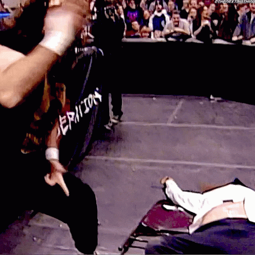 A Wrestler Is Standing In Front Of A Fence That Says Epicon GIF