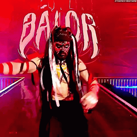 A Wrestler Is Standing In Front Of A Sign That Says " Balor " GIF
