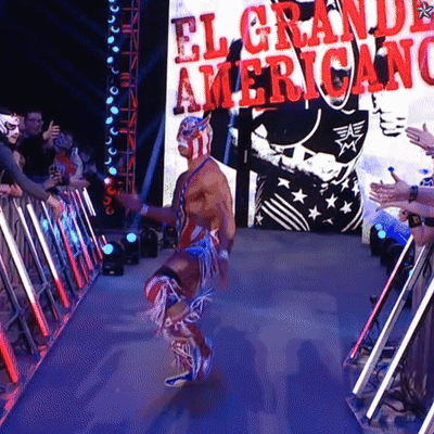 A Wrestler Is Walking Through A Tunnel With A Sign That Says El Grande Americano GIF