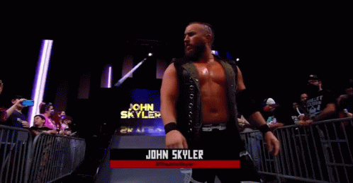 A Wrestler Named John Skyler Is Standing In Front Of A Crowd In A Wrestling Ring . GIF