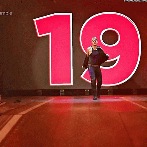 A Wrestler Named King Corbin Walks Down The Aisle In Front Of A Large Number 19 GIF
