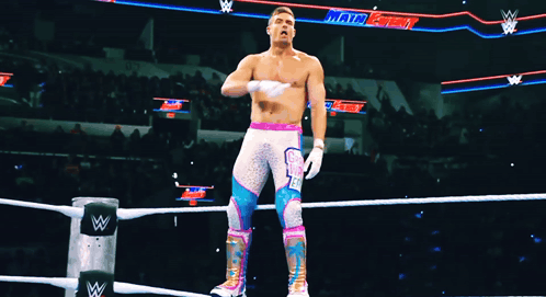 a wrestler stands in a ring with a sign that says main event