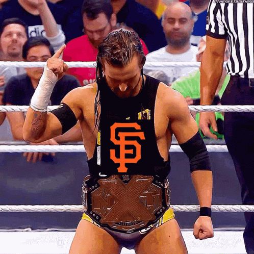 A Wrestler Wearing A San Francisco Giants Shirt Stands In A Ring GIF