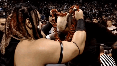 A Wrestler With Dreadlocks Is Holding A Lei Around His Head GIF
