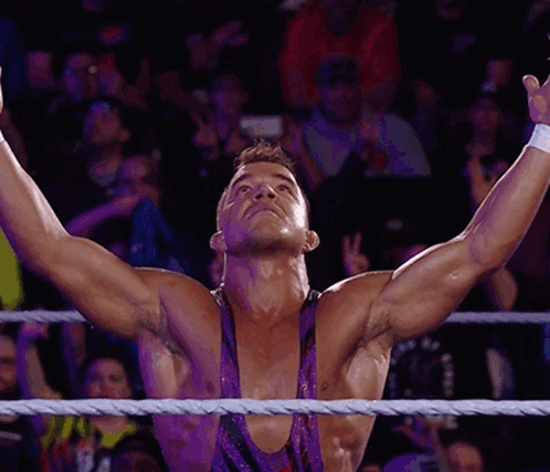 A Wrestler With His Arms Outstretched In The Air GIF