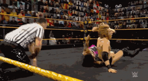 a wrestling match is underway with a w logo in the background