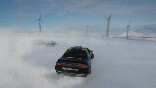 A Yellow And Black Car Is Drifting In The Snow With A Wind Turbine In The Background GIF