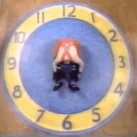 A Yellow And Blue Clock With A Person 'S Head In The Middle GIF