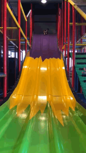 A Yellow And Green Slide With A Purple Top GIF
