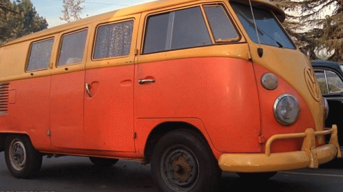 A Yellow And Orange Van With A Vw Logo On The Front GIF