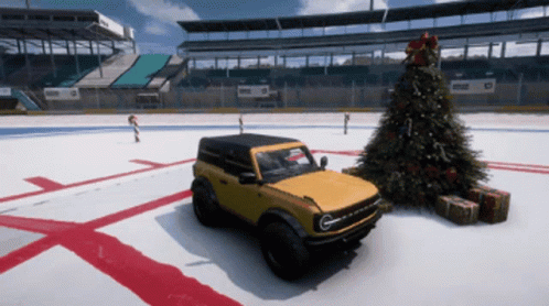 A Yellow Bronco Is Parked Near A Christmas Tree GIF