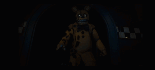 A Yellow Bunny With A Blue Bow Tie Is Standing In A Dark Room GIF