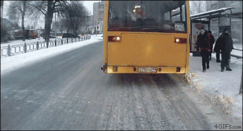 A Yellow Bus With A License Plate That Says Oy27uml Is Driving Down A Snowy Street GIF