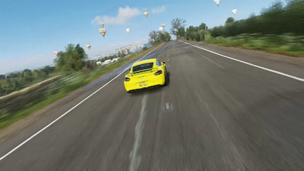 A Yellow Car Is Driving Down A Highway With Hot Air Balloons In The Background GIF