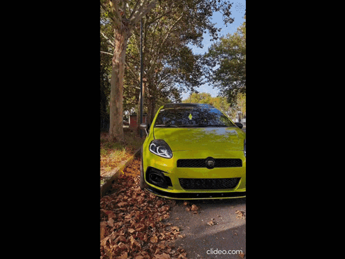 A Yellow Car With The Word Abarth On The Side Is Parked Next To A Tree GIF