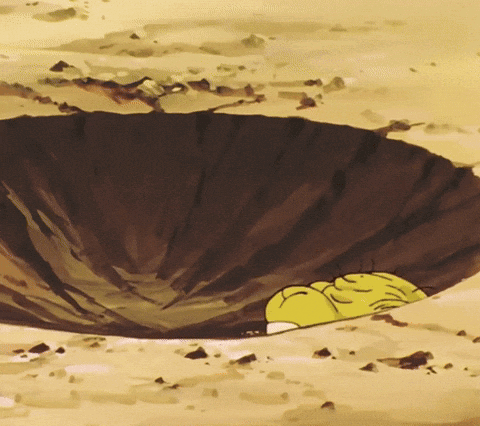 A Yellow Cartoon Character Is Laying In A Hole In The Ground GIF