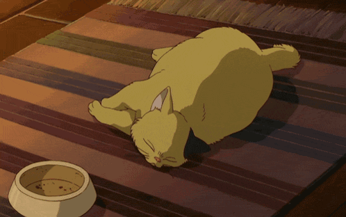 a yellow cat is laying on a striped rug next to a bowl of food