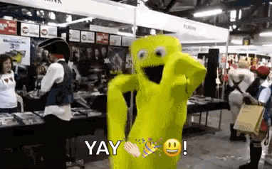 A Yellow Mascot Is Dancing In A Room With People In Costume . GIF