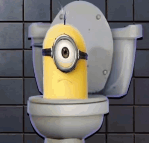 A Yellow Minion Is Sitting On A Toilet With A Sad Look On His Face GIF