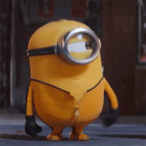 A Yellow Minion Wearing A Yellow Suit And Goggles Is Standing On A Street With His Mouth Open . GIF