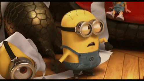 A Yellow Minion Wearing Goggles Is Standing On A Wooden Floor GIF
