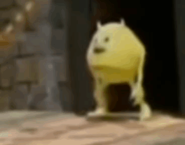 A Yellow Monster From Monsters Inc Is Standing On A Wooden Floor In A Dark Room . GIF