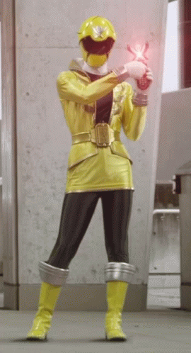A Yellow Ranger Is Holding A Pink Object GIF