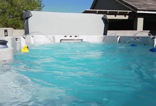 A Yellow Rubber Duck Is Floating In A Pool GIF